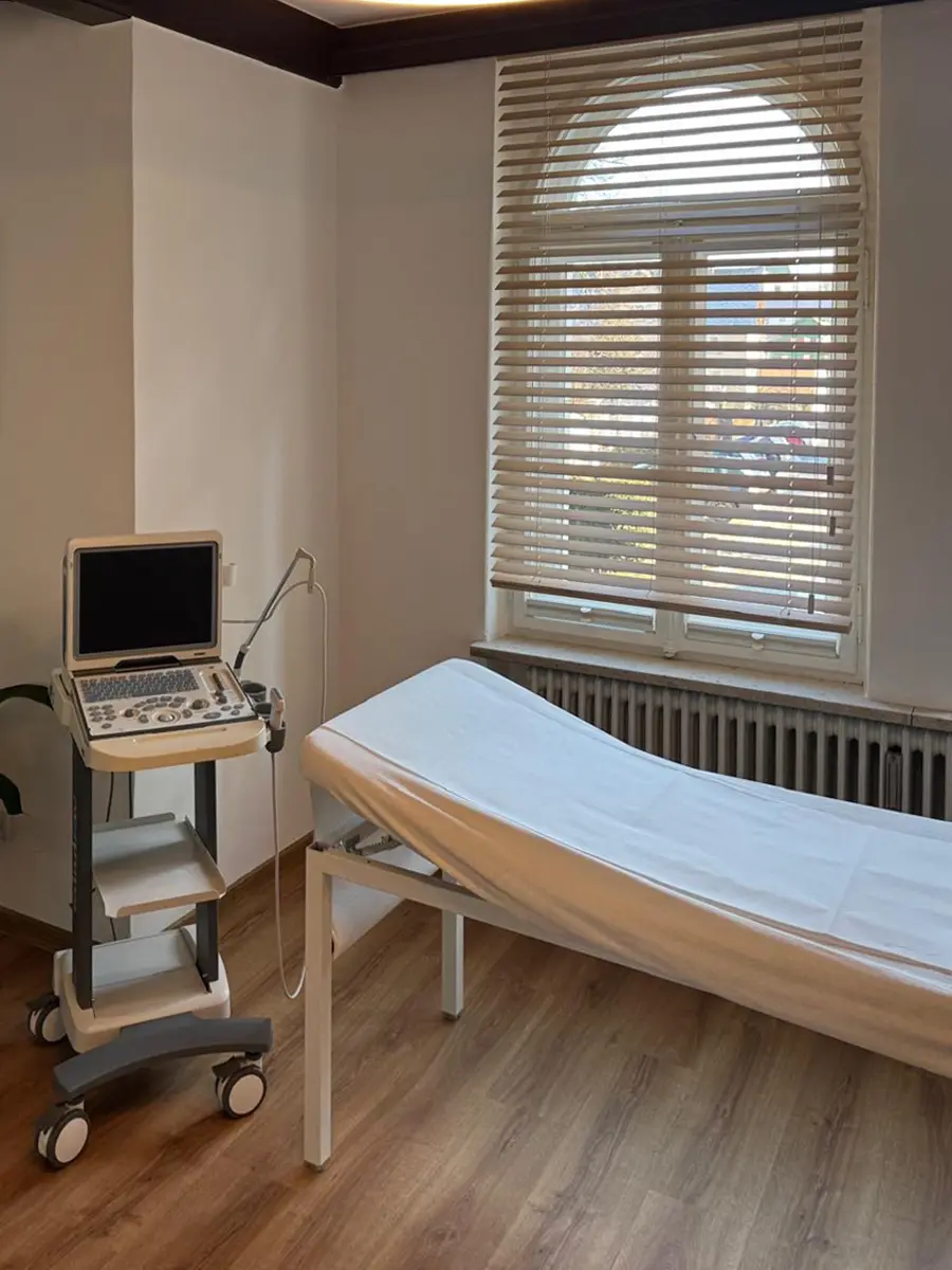 Behandlungsraum mit Liege und Ultraschallgerät