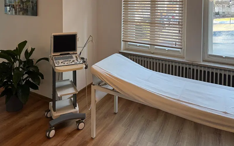 Behandlungsraum mit Liege und Ultraschallgerät